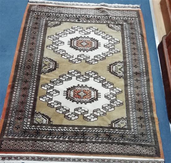 A Bokhara style olive green and cream lozenge patterned rug 154 x 122cm